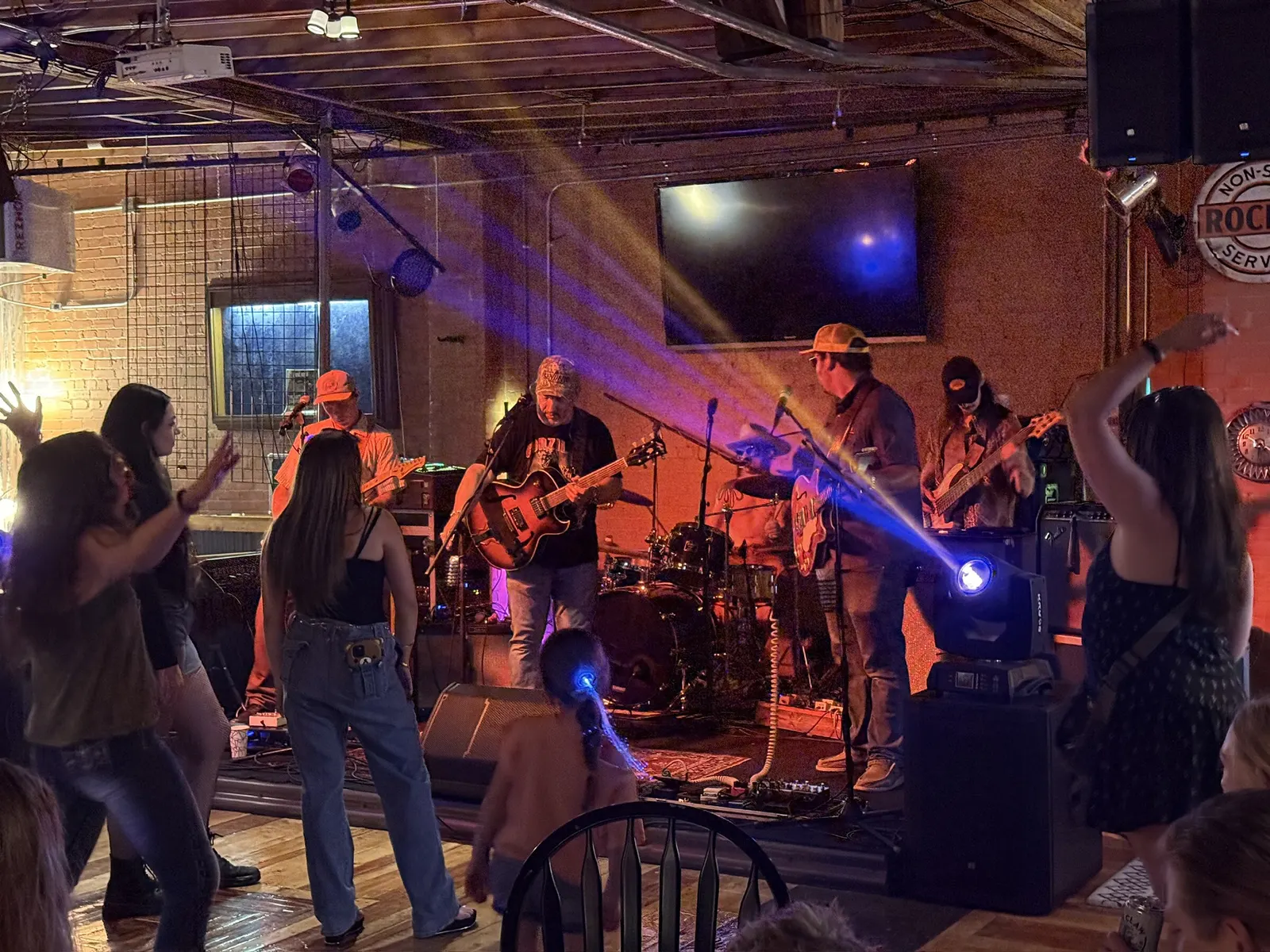 Dancers in front of a band lit with warm stage lights