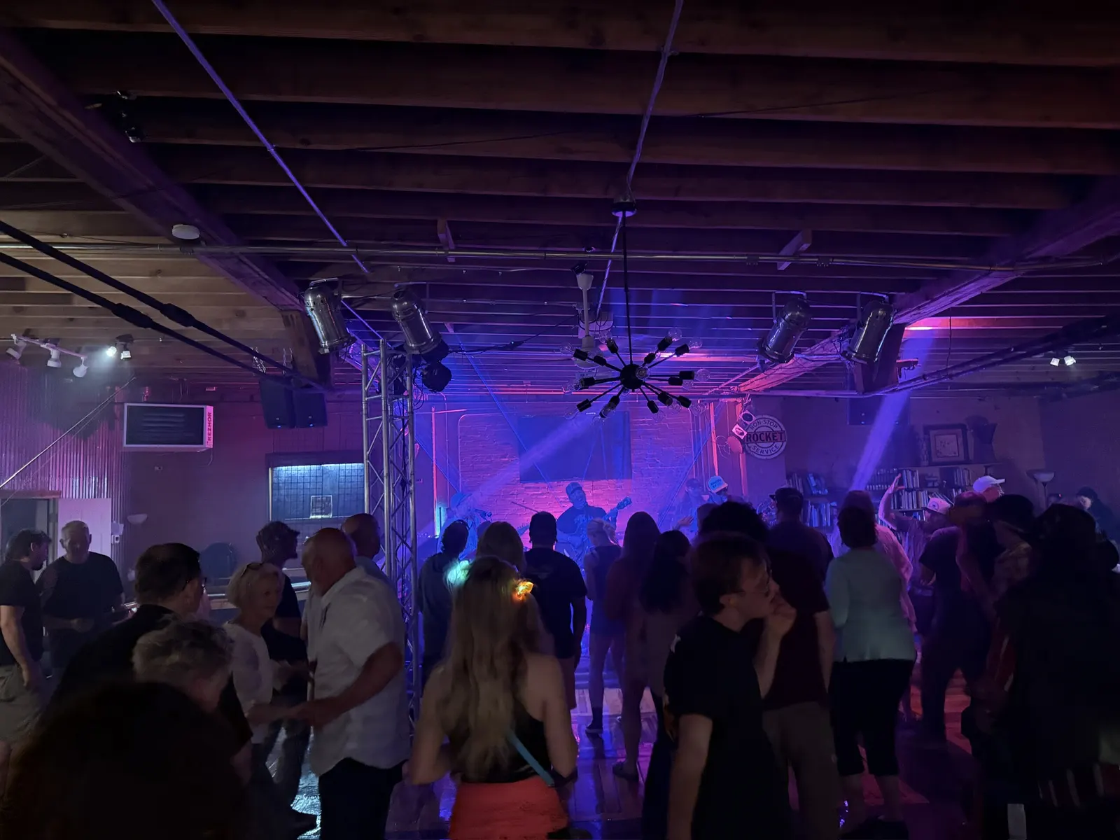 Dancers filling the floor under purple haze