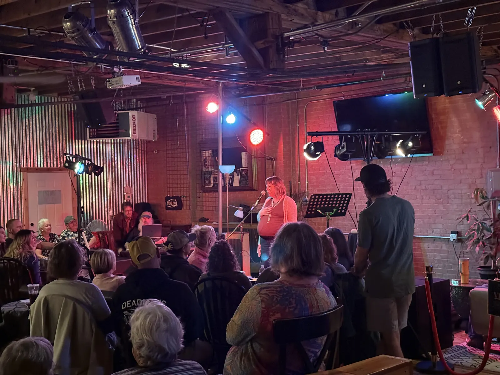 Singer at the mic with the audience gathered close