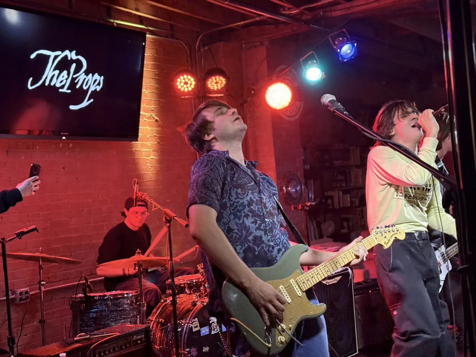 Band on stage with their name on the screen